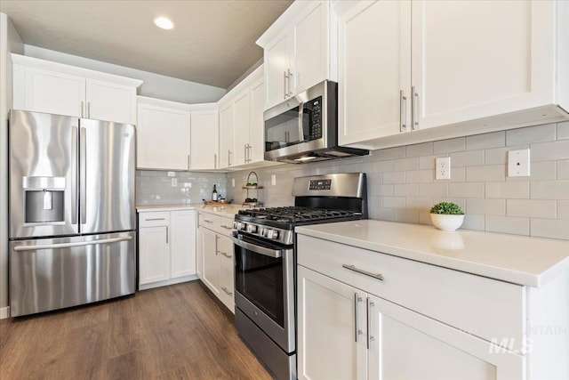 kitchen featuring light countertops, backsplash, appliances with stainless steel finishes, and white cabinetry