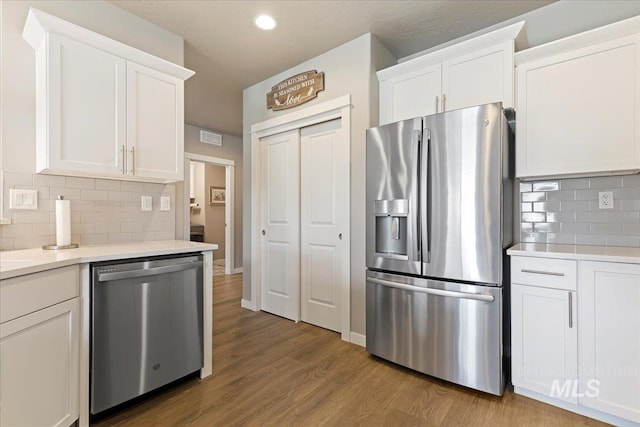 kitchen with visible vents, appliances with stainless steel finishes, wood finished floors, and white cabinets