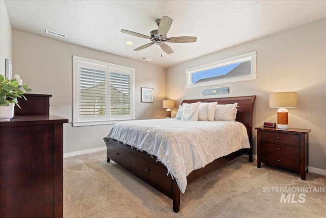bedroom with visible vents, multiple windows, and light carpet