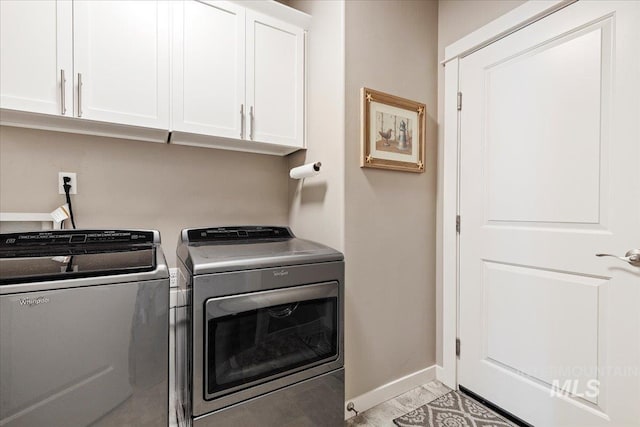 washroom featuring cabinet space, independent washer and dryer, baseboards, and marble finish floor