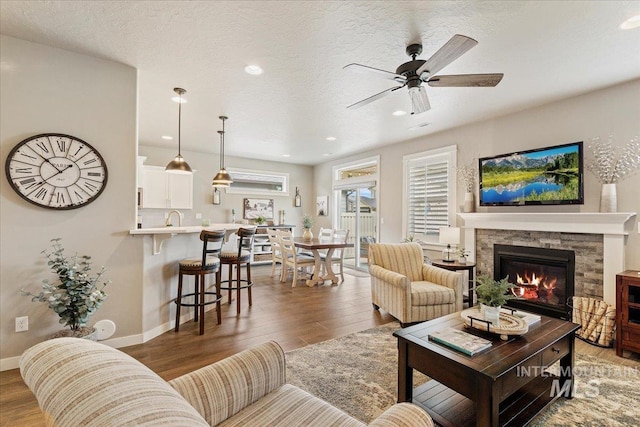 living area featuring baseboards, a ceiling fan, and wood finished floors