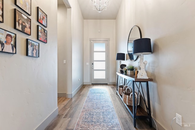 entryway featuring hardwood / wood-style flooring and an inviting chandelier