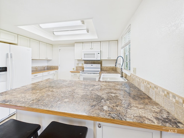 1673 Thomas, Emmett, ID 83617 - kitchen featuring white appliances, a peninsula, a tray ceiling, and white cabinets