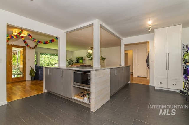 2844 Parke Circle Dr, Boise, ID 83705 - kitchen with stainless steel microwave, light countertops, dark tile patterned floors, and white cabinetry