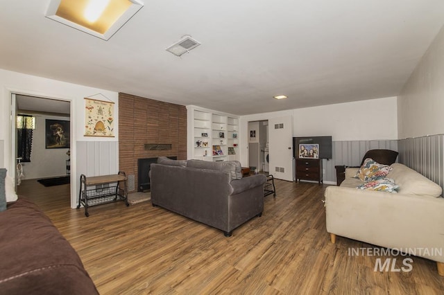 2844 Parke Circle Dr, Boise, ID 83705 - living area with wood finished floors, a wainscoted wall, built in shelves, and a brick fireplace