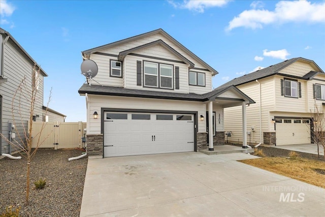 view of front of property featuring a garage, stone siding, and driveway