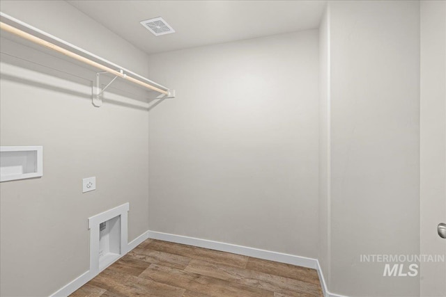 laundry area featuring hookup for an electric dryer, laundry area, wood finished floors, visible vents, and baseboards