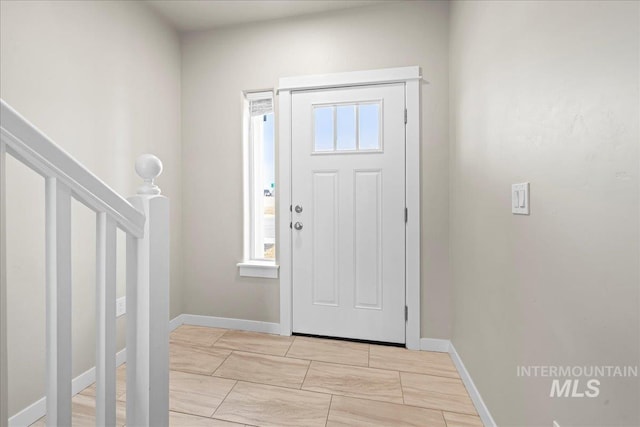 entryway with baseboards and stairs