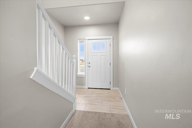 entryway featuring baseboards and stairs