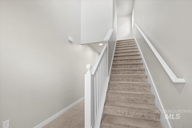 staircase featuring carpet flooring and baseboards