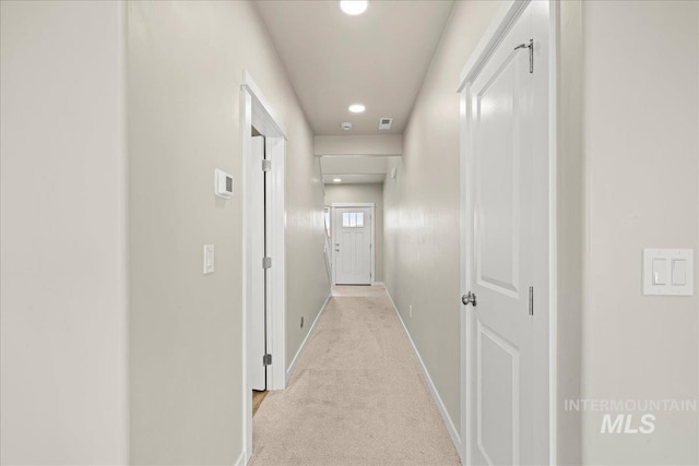 hall with baseboards, recessed lighting, and light colored carpet