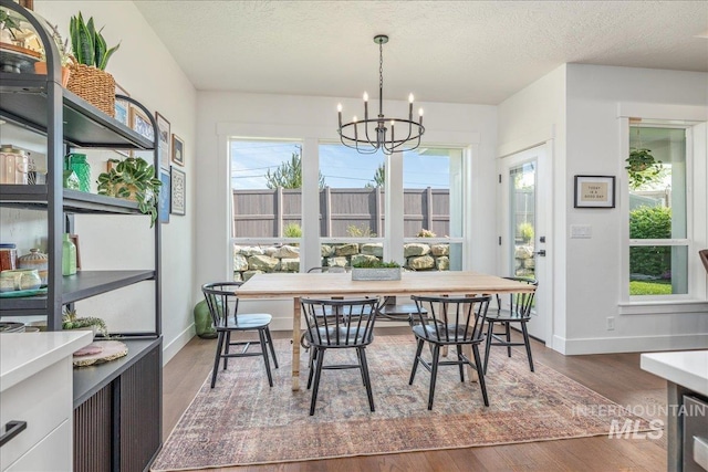 11328 W Campanula Dr, Star, ID 83669 - dining room with a chandelier, dark wood-style flooring, baseboards, and a textured ceiling