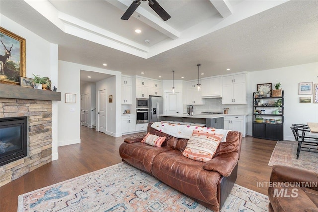 11328 W Campanula Dr, Star, ID 83669 - living area featuring a ceiling fan, dark wood-style flooring, recessed lighting, a fireplace, and beam ceiling