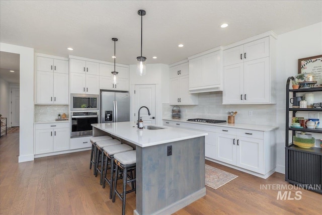 11328 W Campanula Dr, Star, ID 83669 - kitchen with a sink, appliances with stainless steel finishes, dark wood-style floors, light countertops, and tasteful backsplash