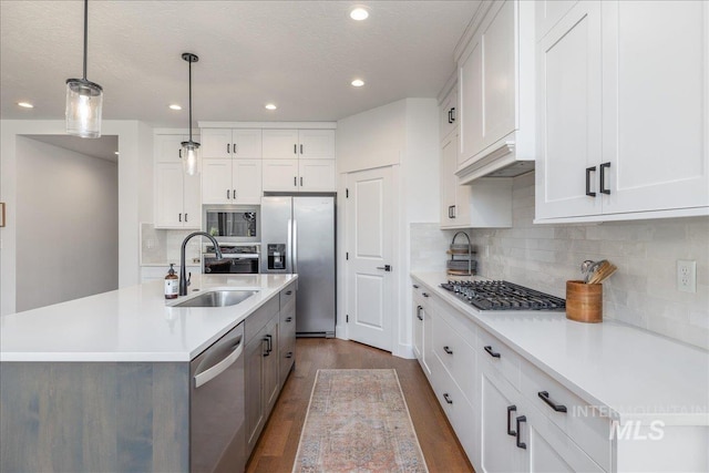 11328 W Campanula Dr, Star, ID 83669 - kitchen with appliances with stainless steel finishes, a sink, light countertops, recessed lighting, and dark wood-style floors