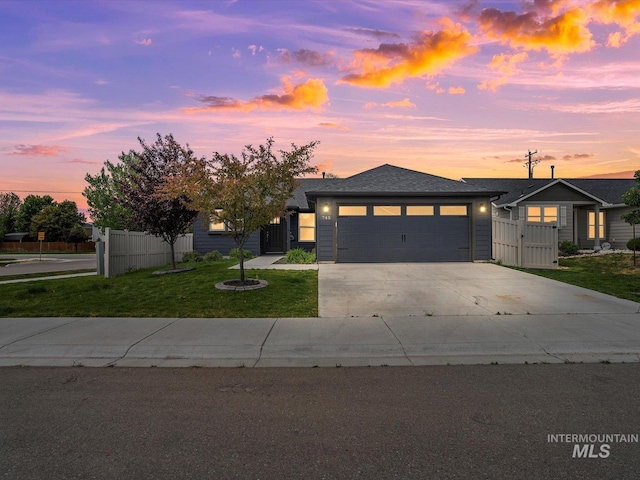 view of front of home with an attached garage, driveway, a gate, and a shingled roof