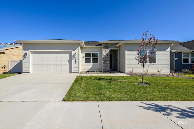 view of front of home featuring concrete driveway, a front lawn, and a garage