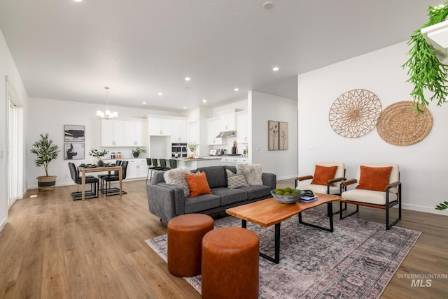 living room with a chandelier and light hardwood / wood-style floors