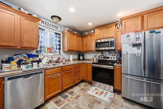 909 Arrow Wood Ct, Twin Falls, ID 83301 - kitchen featuring appliances with stainless steel finishes, a sink, light countertops, recessed lighting, and stone finish floors