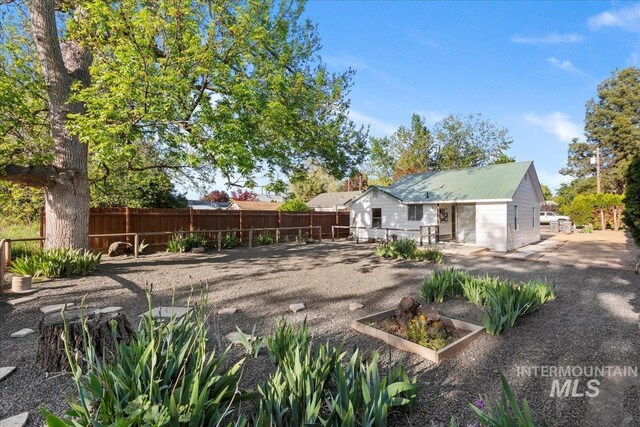 1223 N Mckinney St, Boise, ID 83704 - back of property with fence, metal roof, and a vegetable garden