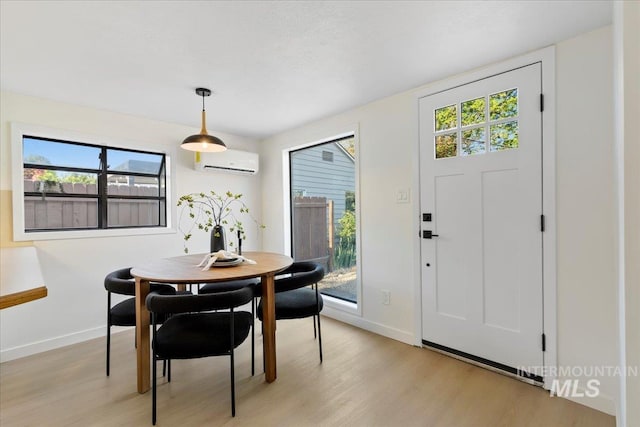 1223 N Mckinney St, Boise, ID 83704 - dining area with baseboards, a wall mounted AC, and light wood-type flooring