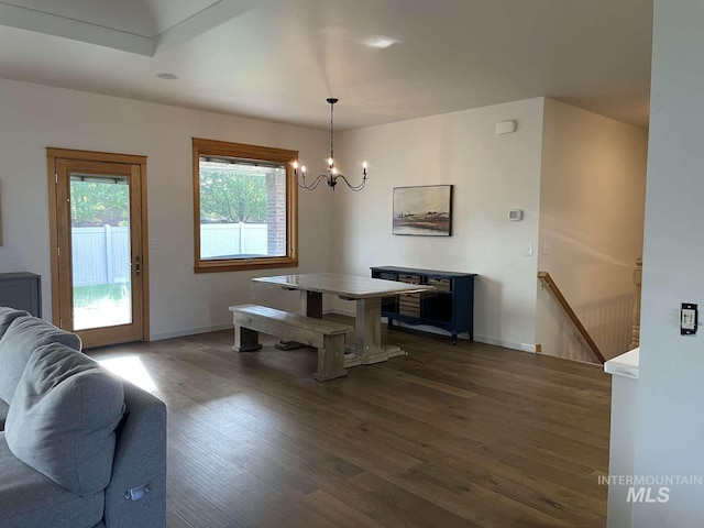 dining area featuring dark wood-type flooring and a chandelier