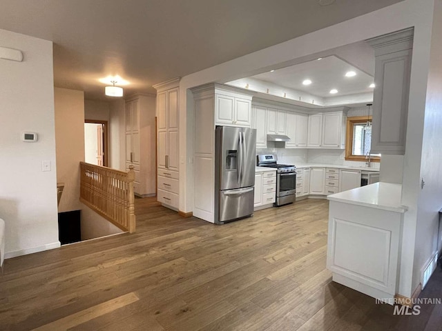 kitchen featuring white cabinetry, appliances with stainless steel finishes, sink, and light wood-type flooring