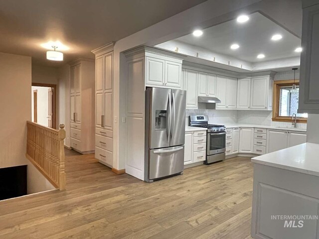 kitchen featuring pendant lighting, sink, white cabinetry, and stainless steel appliances