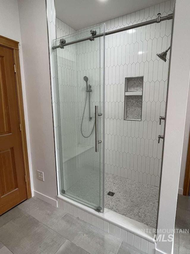 bathroom featuring an enclosed shower and tile patterned floors