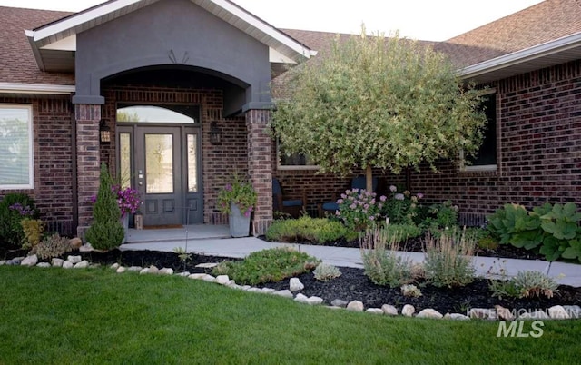 property entrance featuring a lawn