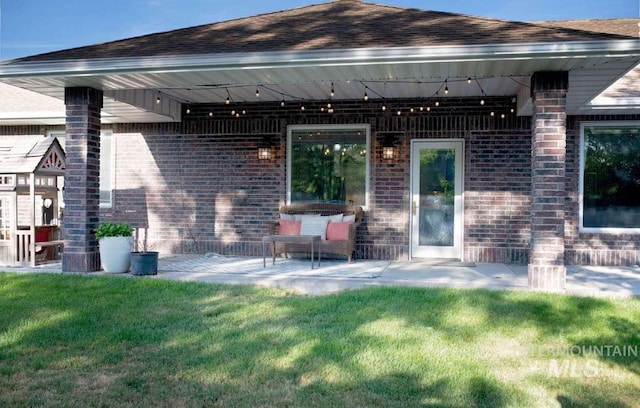 rear view of house with a patio and a lawn