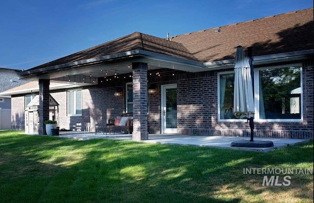 back of house with a patio and a yard