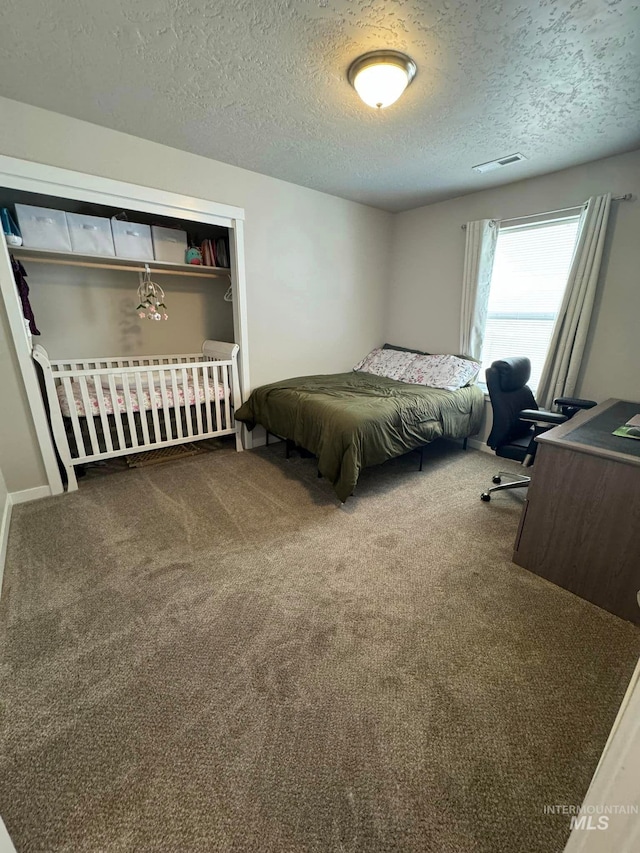 carpeted bedroom with visible vents and a textured ceiling