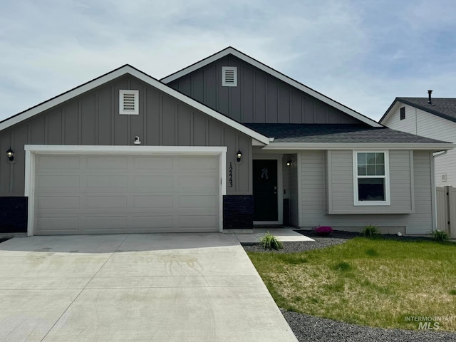 ranch-style house with a front yard, driveway, an attached garage, a shingled roof, and board and batten siding