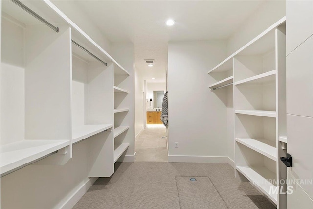 walk in closet featuring light carpet