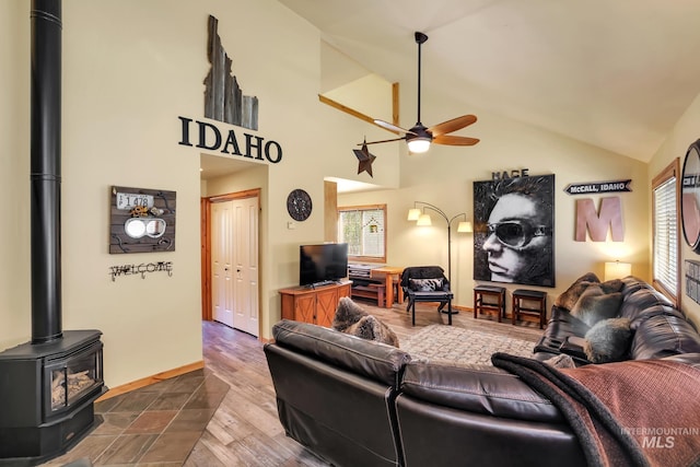 141 Stibnite St Unit 15, Mccall, ID 83638 - living area with a ceiling fan, a wood stove, dark wood-style flooring, baseboards, and high vaulted ceiling