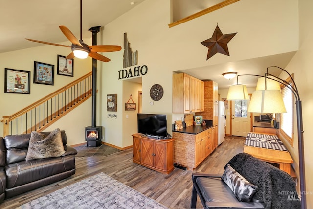141 Stibnite St Unit 15, Mccall, ID 83638 - living area featuring wood finished floors, ceiling fan, a wood stove, high vaulted ceiling, and baseboards