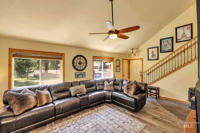 141 Stibnite St Unit 15, Mccall, ID 83638 - living area featuring a ceiling fan, stairs, wood finished floors, a wood stove, and high vaulted ceiling