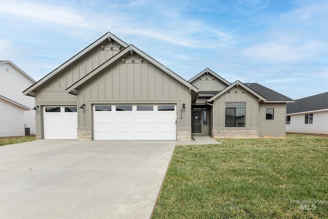 view of front of house featuring stone siding, concrete driveway, a garage, board and batten siding, and a front yard
