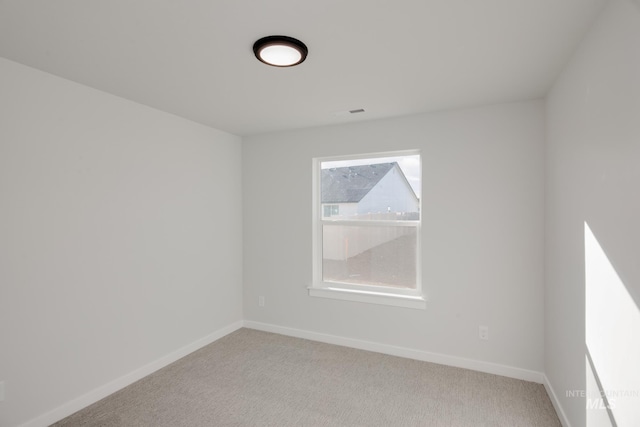 carpeted empty room with visible vents and baseboards