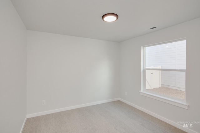 empty room with visible vents, baseboards, and light carpet
