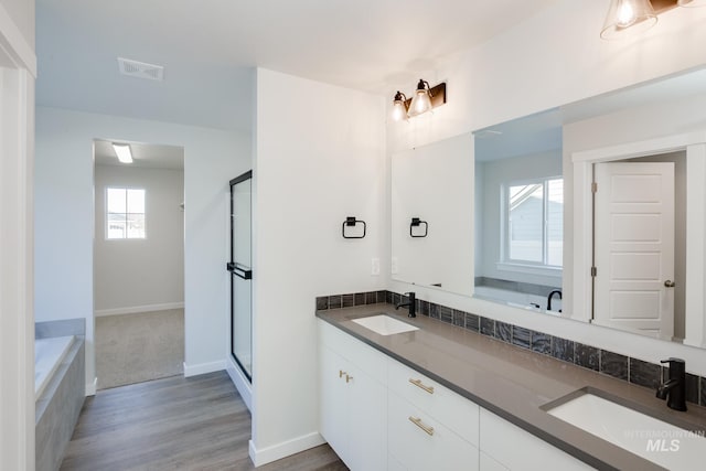 full bath featuring double vanity, a sink, visible vents, and a stall shower