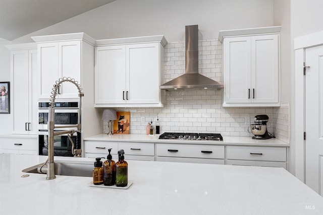 20513 N Glenisla Ave, Boise, ID 83714 - kitchen with light countertops, backsplash, white cabinetry, appliances with stainless steel finishes, and wall chimney range hood