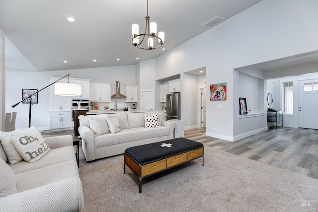 20513 N Glenisla Ave, Boise, ID 83714 - living room with high vaulted ceiling, visible vents, light wood finished floors, recessed lighting, and a notable chandelier