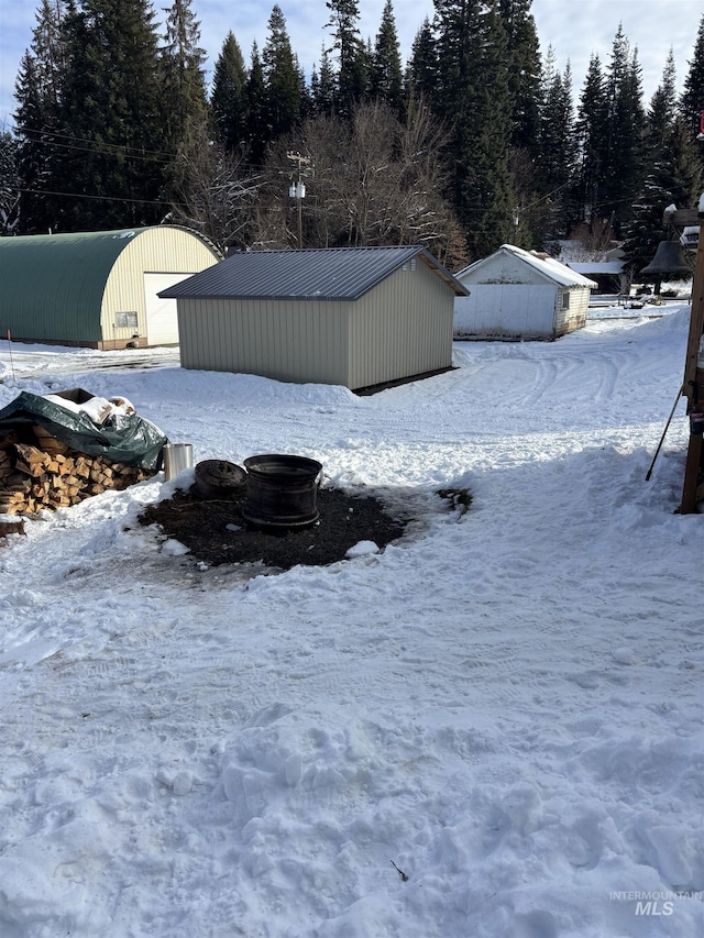 yard layered in snow with an outdoor structure