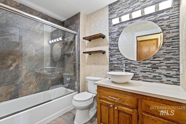 full bathroom featuring tile walls, combined bath / shower with glass door, toilet, and backsplash