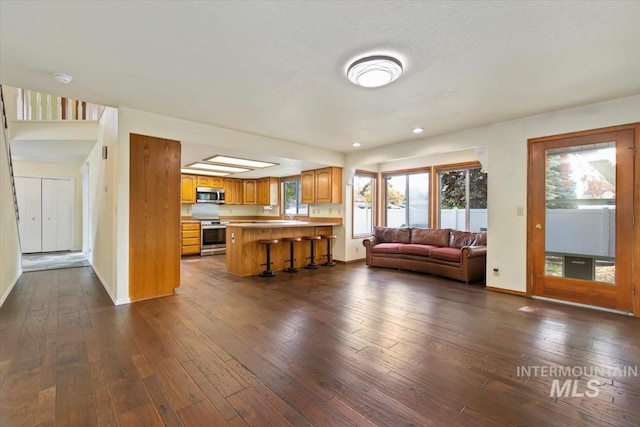 unfurnished living room featuring plenty of natural light and dark hardwood / wood-style flooring