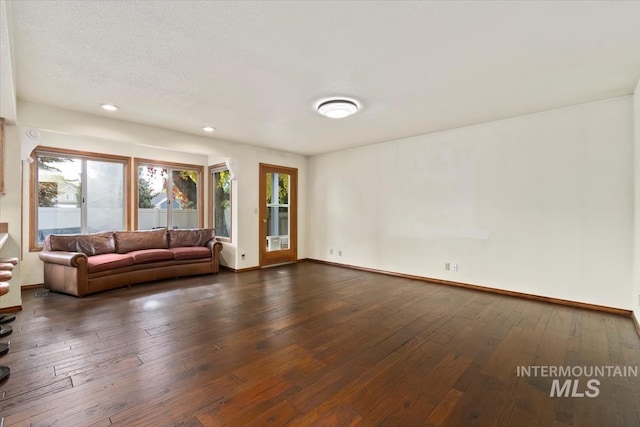 unfurnished living room with dark wood-type flooring