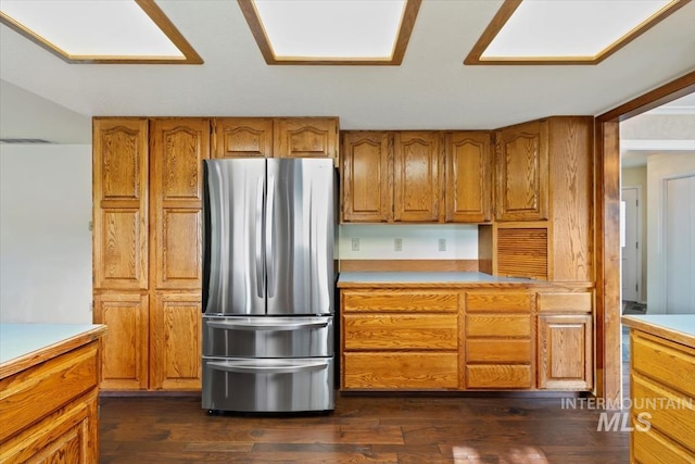 kitchen with dark hardwood / wood-style flooring and stainless steel fridge