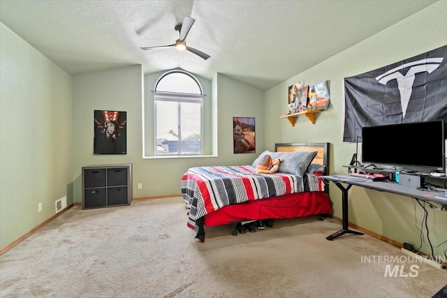 carpeted bedroom with a textured ceiling, lofted ceiling, and ceiling fan